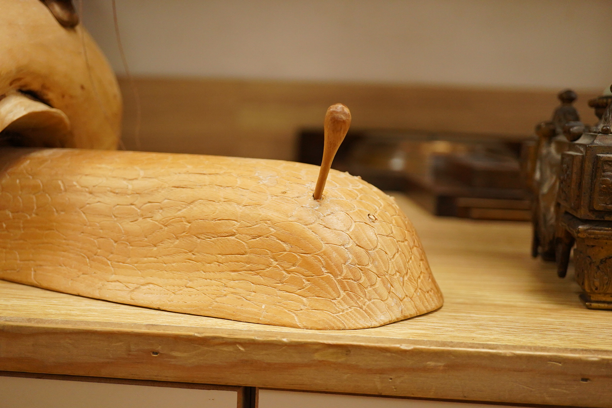 Pierre Decorse (b.1953), a naturalistically modelled wooden sculpture depicting a figure riding a snail, 53cm long